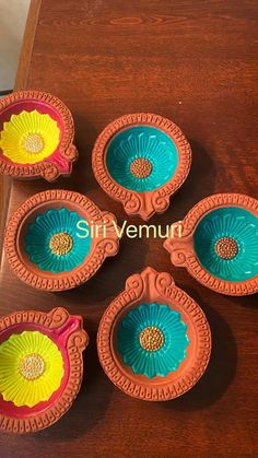 four colorful dishes sitting on top of a wooden table