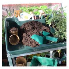 the garden is full of dirt and gardening utensils, including some green plants