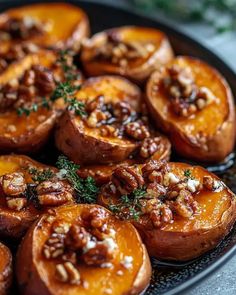 baked sweet potatoes with pecans and walnuts on a black plate, ready to be eaten