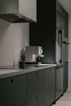 a kitchen with white cabinets and black counter tops is seen in this image from the side view