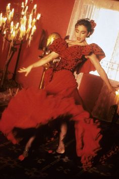 a woman in a red dress is dancing