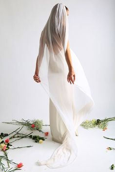 a woman in a white dress with flowers around her