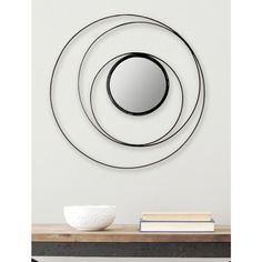 a white bowl sitting on top of a table next to a black and white mirror