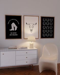 a white chair sitting next to a table with two pictures on the wall above it