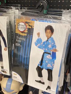 two children's costumes are on display for sale in a store, one is blue and the other is black