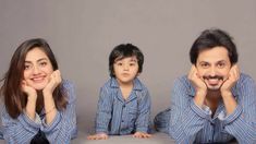 three people sitting on the floor with their faces close to each other, one man and two women