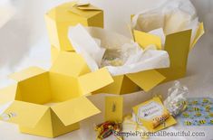 some yellow boxes are sitting on the table with candy and candies in front of them