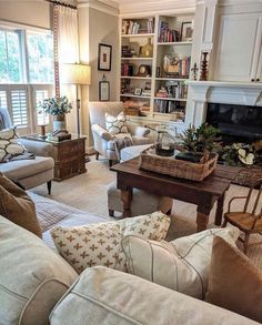 a living room filled with lots of furniture and a fire place in the middle of it