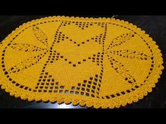 a yellow crocheted doily with an image of a cat in the center