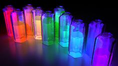 there are many different colored glass bottles in the dark together, one is lit up and the other is empty