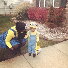 a woman and child dressed up as minions from the movie despicables standing in front of a house