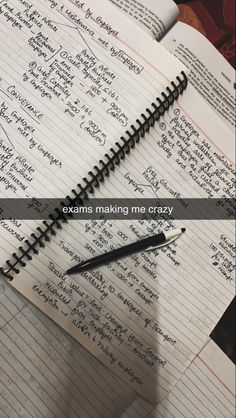 an open notebook sitting on top of a table next to a pen and paper with the words exam making me crazy