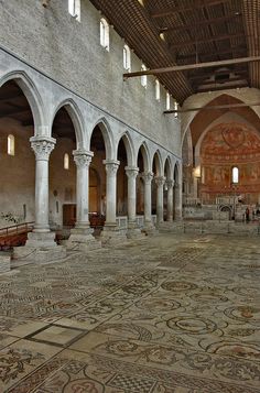 the interior of an old building with stone arches and floor tiles on the ground,