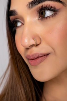 a close up of a woman wearing a nose ring