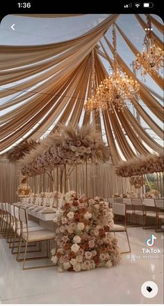 an image of a wedding setup with flowers and chandeliers on the ceiling,