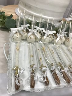 there are many white and gold items in the package on the table with green leaves