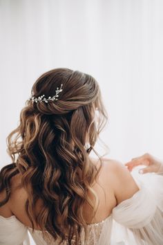 a woman with long hair wearing a white dress and a tiara on her head