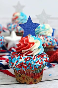 patriotic cupcakes with red, white and blue frosting on wooden table top