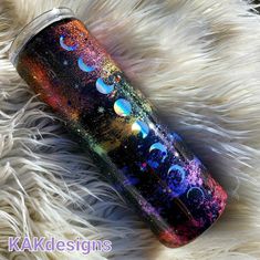 the outer planets are visible in this colorful tumbler cup that is on top of white fur