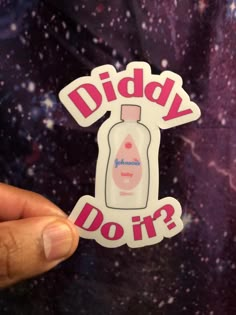 someone holding up a sticker that says diddy do it? in front of a space background