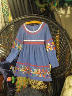 "70s border print blue dress with embroidered florals and zig zag trim. It's a mini dress with an empire  waist seam and long puffy sleeves gathered to 5 1/2\" long fitted cuffs. Made of a textured cotton blend, it has colors of red, green, orange, blue and white leaves & flowers with red and white zig zag rik-rak trim. It's a floral border print that makes good use of the patterns. The blue metal zipper tab says Robin! The neckline is a scoop style, and the bodice is fitted with darts, a gently gathered skirt, and long sleeves. It zips on the back. No tags. It fits like a modern USA size 2 -4 - (about), A size Xtra Small , No stretch. bust - 34\"   empire waist seam- 25\"     bodice length - 11 1/2\"                     hips - 48\"  back shoulders - 14\" sleeves - 22\" wrist - 7\" Length Vintage Floral Embroidered Dress For Fall, Vintage Cotton Dress With Bishop Sleeves, Vintage Embroidered Fall Dresses, Blue Retro Vintage Dress For Spring, Retro Blue Vintage Dress For Spring, Vintage Long Sleeve Floral Embroidery Dress, Vintage Long Sleeve Dress With Floral Embroidery, Vintage Blue Embroidered Dresses, Vintage Smock Dress For Spring