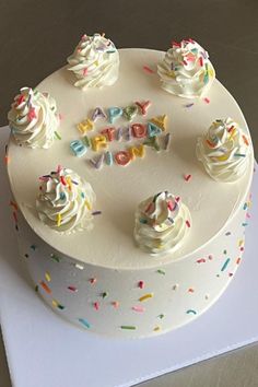 a birthday cake with white frosting and sprinkles on the top that says happy birthday