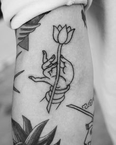 a woman's arm with tattoos on it and a flower in the middle of her arm