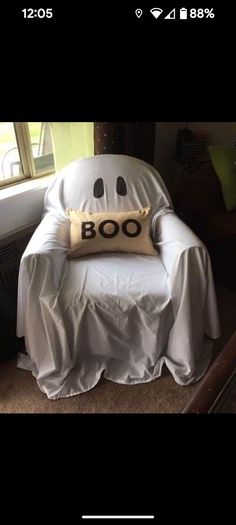 a white chair with a ghost pillow on it's back in front of a window