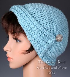 a close up of a mannequin head wearing a knitted hat with buttons