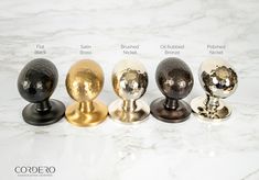 four different types of door knobs on a white marble counter top with black, gold and silver handles