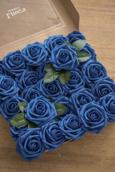 a box with blue roses in it sitting on a table