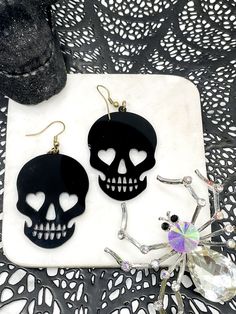 💀 Stand out with your statement earrings, these are fun and lightweight and sure to make any outfit pop! Perfect for Halloween time to wear and jazz up your costume or party outfits! Available in white, black, glitter silver, glitter gold, and glitter red! 💀 Length: 2"Width: 1.5" *♡* Please note that each item is handmade and colors may reflect slight differences than the ones pictured. Due to the delicate nature of the stones/rhinestones/beads, I am not responsible if you mishandle your earri Edgy Skull Earrings For Parties, Black Novelty Jewelry For Costume Party, Rave Jewelry For Halloween Party, Black Skull Print Earrings As Gift, Punk Skull Earrings For Party, Black Skull-shaped Earrings With Skull Print, Black Spooky Jewelry For Party, Black Spooky Party Jewelry, Spooky Black Jewelry For Party