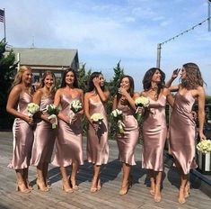 a group of women standing on top of a wooden deck