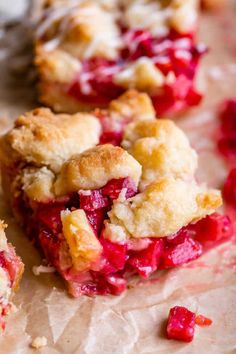 several pieces of pie sitting on top of a piece of wax paper with crumbled toppings