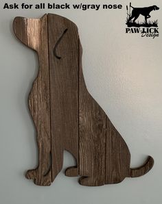 a dog shaped wooden sign hanging from the side of a wall with an image of a dog on it's back