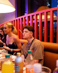 three people sitting at a table with drinks and condiments in front of them