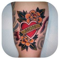 a woman's leg with tattoos on it and flowers in the shape of a heart