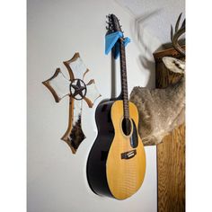 a deer head mounted to the side of a wall next to a guitar