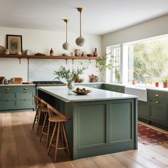 a kitchen with green cabinets and wooden floors