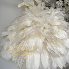 a dress made out of white feathers and flowers