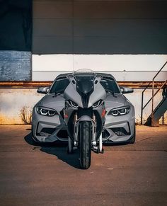 two motorcycles parked next to each other in front of a building with a car behind them