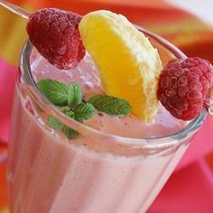 a drink with raspberries, lemon and mint garnish