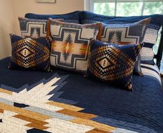 a bed topped with pillows and blankets next to a window