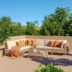 a couch and table on a patio with trees in the background