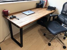 an office desk with a laptop computer on it and two chairs in front of it