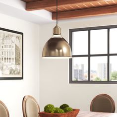 a dining room table with chairs and a bowl of green vegetables on the centerpiece