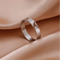 a wedding ring with an arrow on it is laying on a satin fabric in this image