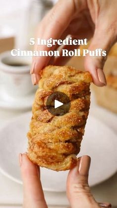 someone holding up a piece of bread with an olive on it and the words 5 ingredient cinnamon roll puffs