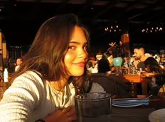 a woman sitting at a table with a glass in front of her