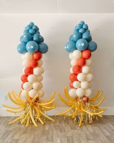 two tall balloons are decorated with gold and blue streamers